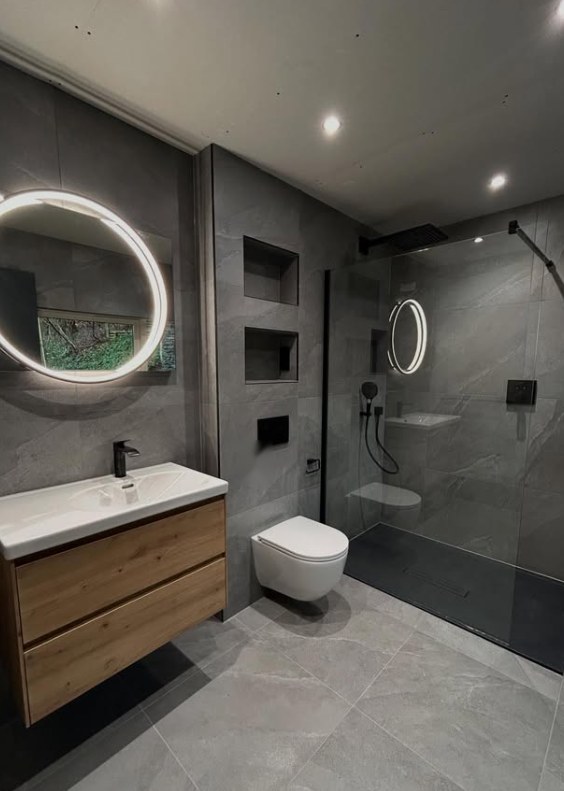 Grey wetroom with walk-in shower, round LED mirror and oak vanity unit