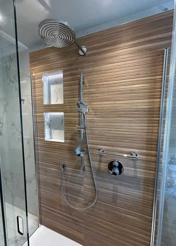 Walk-in shower with walnut-effect panelling, twin illuminated niches and rainfall head